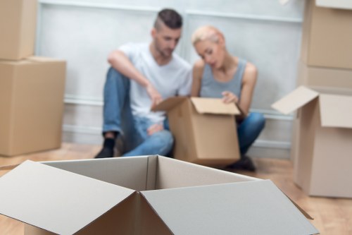 Removal movers carrying furniture down stairs in a Balham property